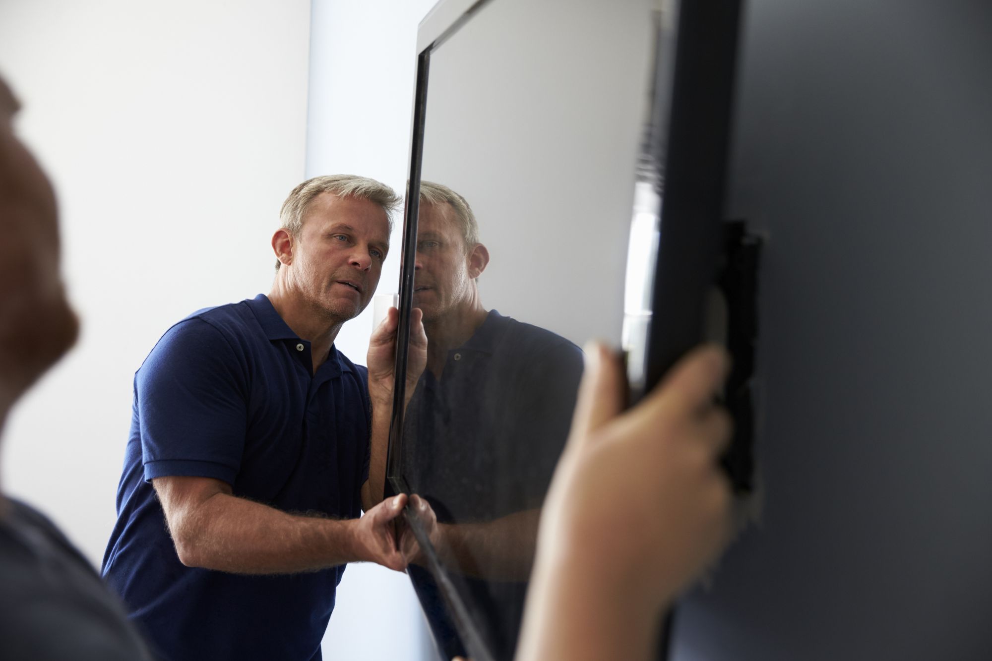 A handyman mounting a TV